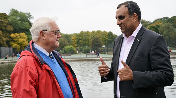 Shaffaq Mohammed speaking to a man in Millhouses Park