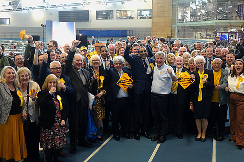 The Sheffield Lib Dem team cheering inside a sports hall